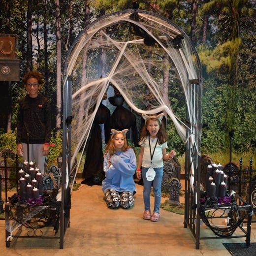 three siblings posing in halloween decor