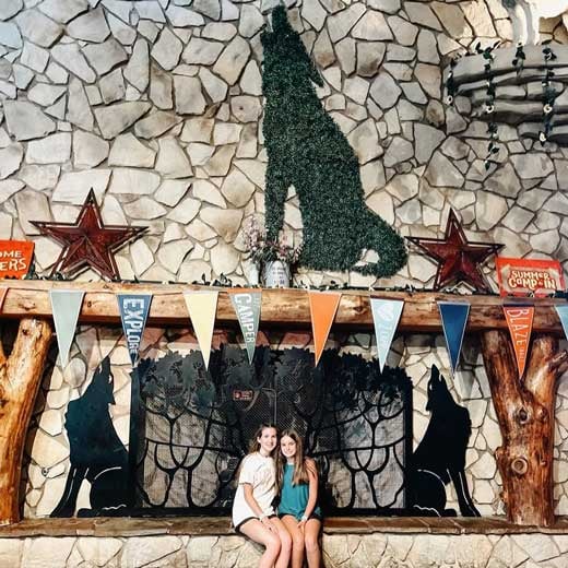 two sisters holding each other in front of a chimney