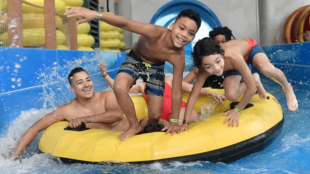family sliding down a water slider 