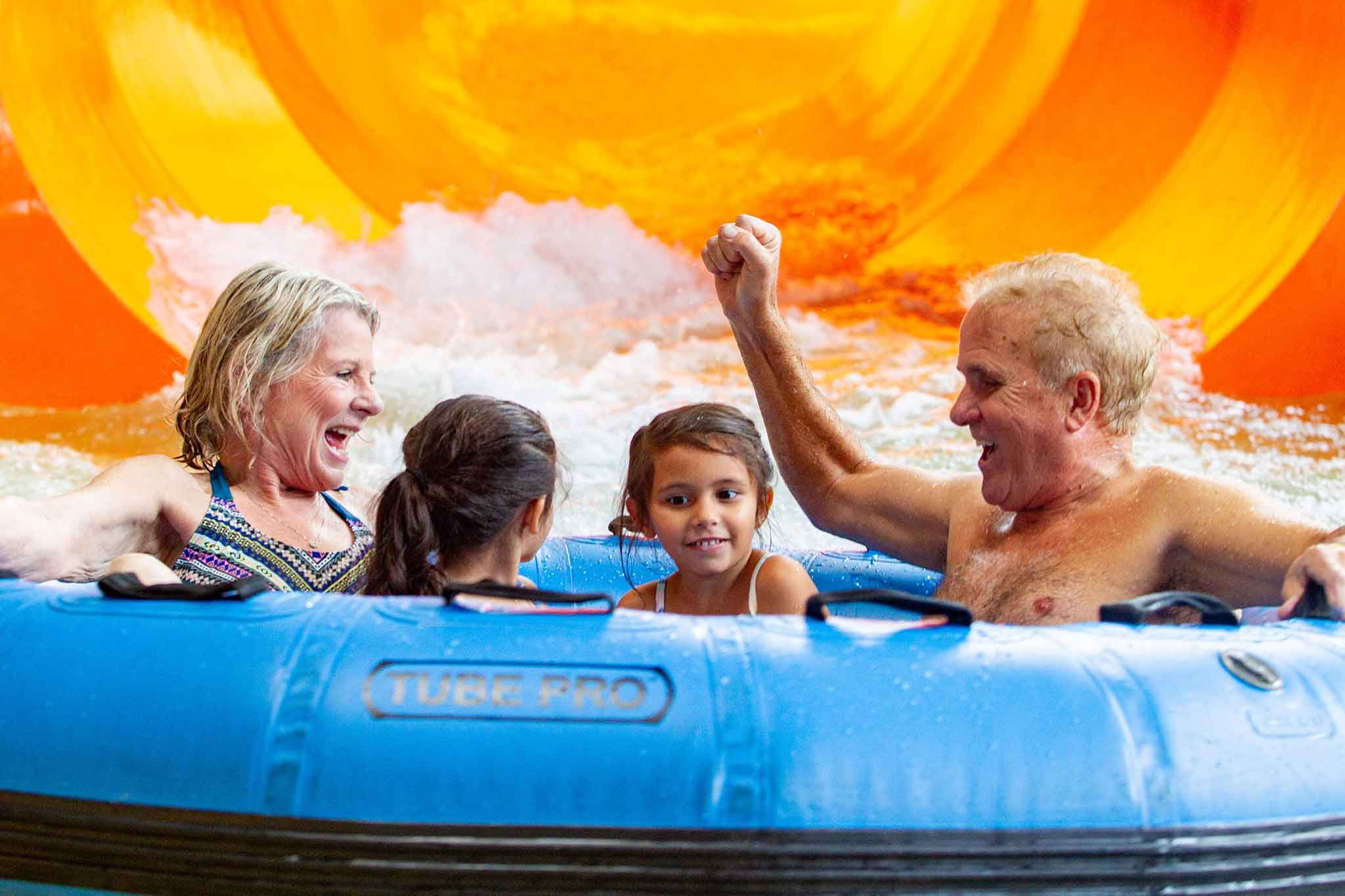 Grandparents and Grand-daughters slide down the water slide 