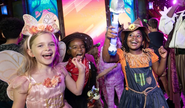 Children in costumes at colorful indoor entertainment venue