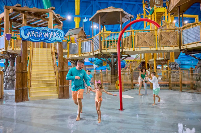 family standing in front of water fort laughing and enjoying