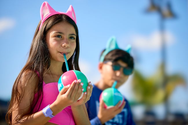 Kids in swimsuits drinking frozen drinks in the sun