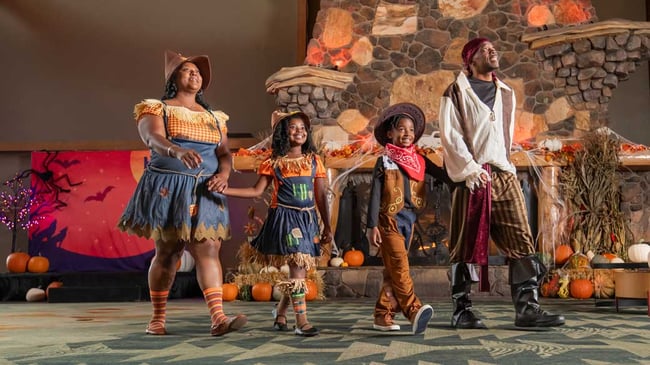 family wearing halloween costumes and walking in lobby