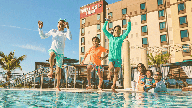 three children jumping into a pool making a splash
