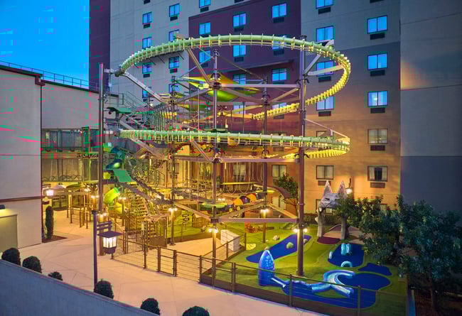 Smiling girl in harness on a rope bridge