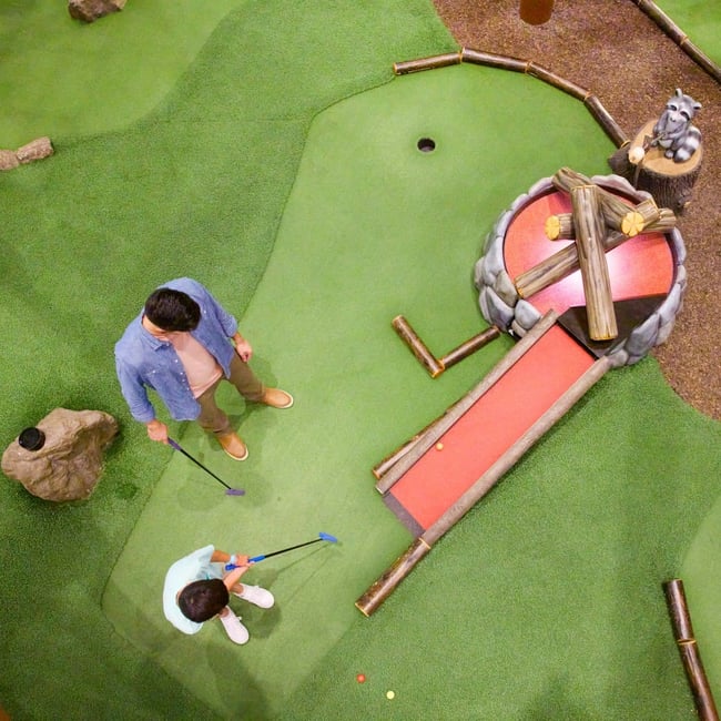 Family play a round of mini golf