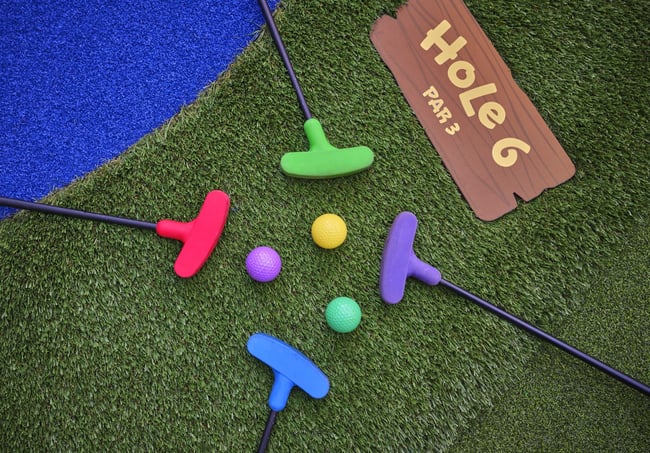 Overhead shot of a family playing mini golf