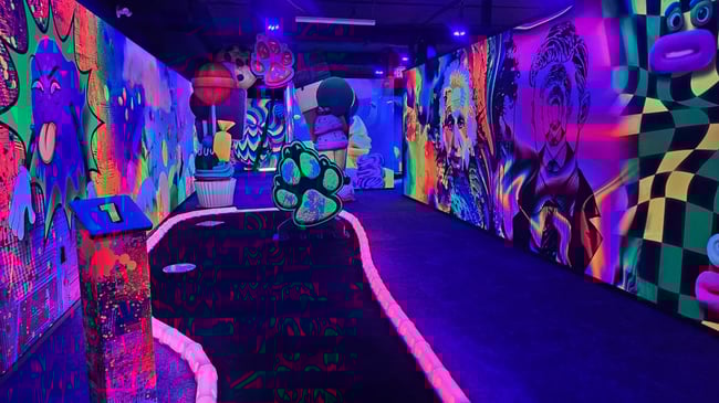 Neon blacklight mini golf course with art