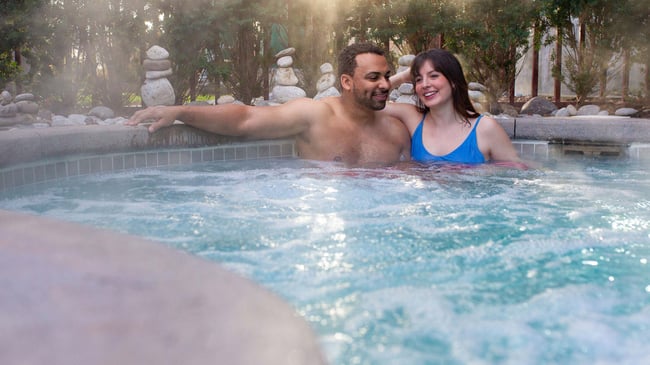 A couple relaxes in an outdoor hot tub