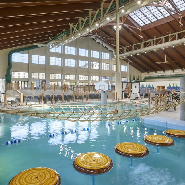 Indoor water park scene with a rope bridge