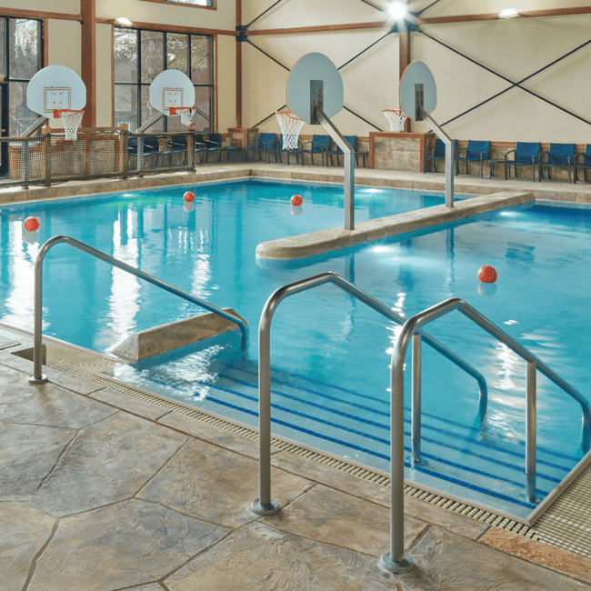  A spacious indoor pool featuring a large slide and multiple water slides for recreational enjoyment.