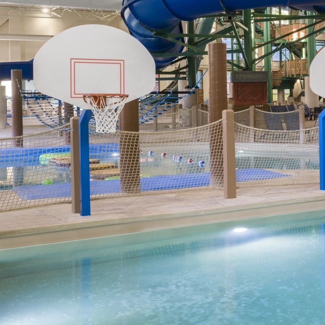A vibrant water park featuring a basketball hoop and multiple water slides for fun and recreation.