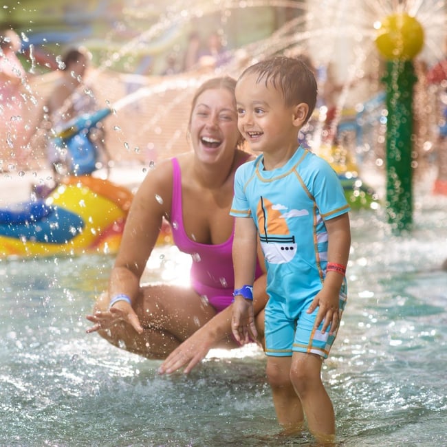 mother and child playing in a kiddie pool