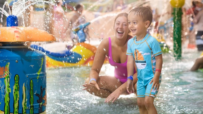mother and child playing in a kiddie pool