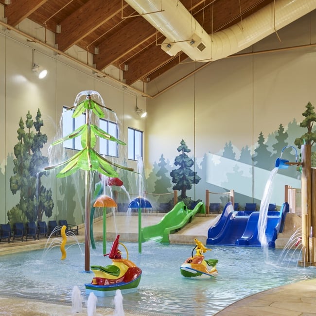 little boy about to go down a yellow kiddie slide