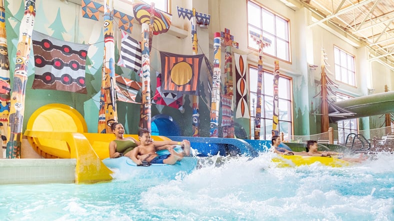 Family enjoying Bobcat Falls at Great Wolf Lodge indoor water park and resort.
