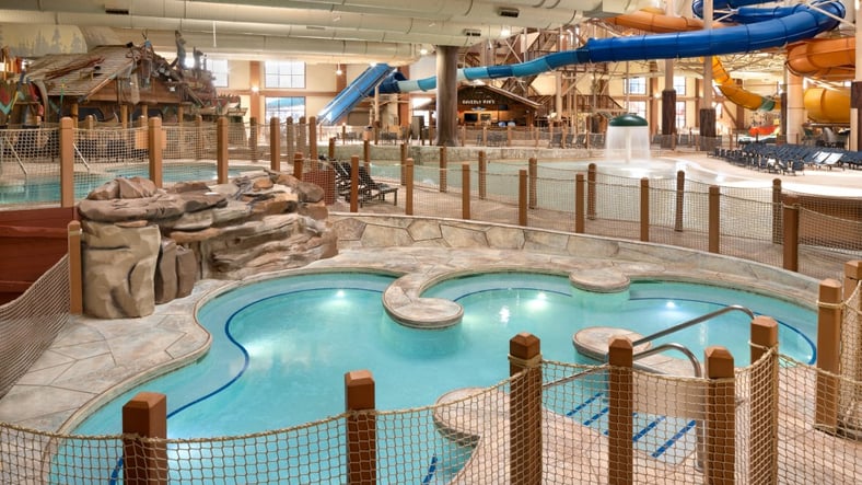 A family of four relaxes in the indoor pool