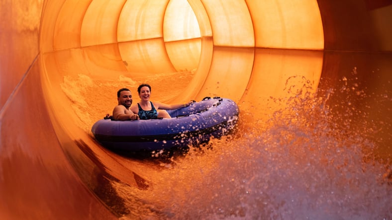 A family enjoys rafting together at Great Wolf Lodge indoor water park and resort.