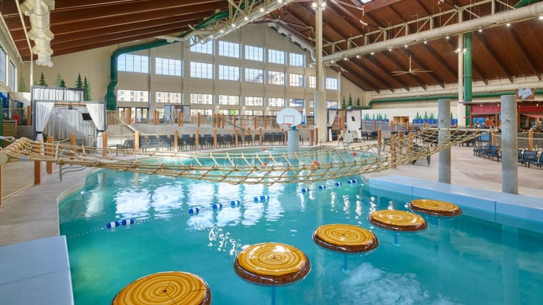 family playing basketball in indoor pool 