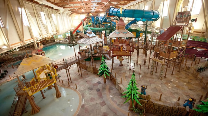 A wide shot of the  water treehouse as water splashes down from a bucket above the jungle gym