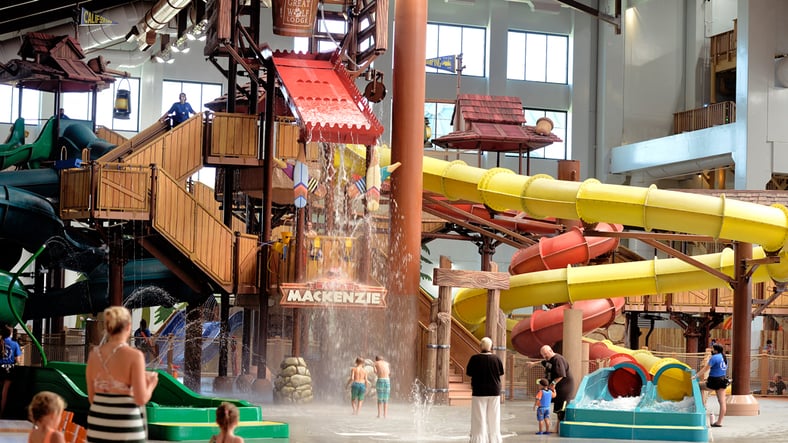 A wide shot of the  water treehouse as water splashes down from a bucket above the jungle gym