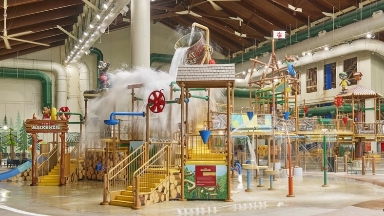A wide shot of the  water treehouse as water splashes down from a bucket above the jungle gym