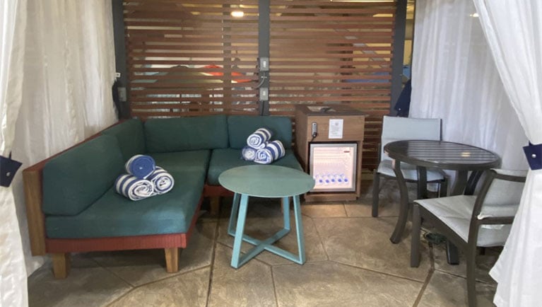 indoor cabana with sofa seating, towels and fridge