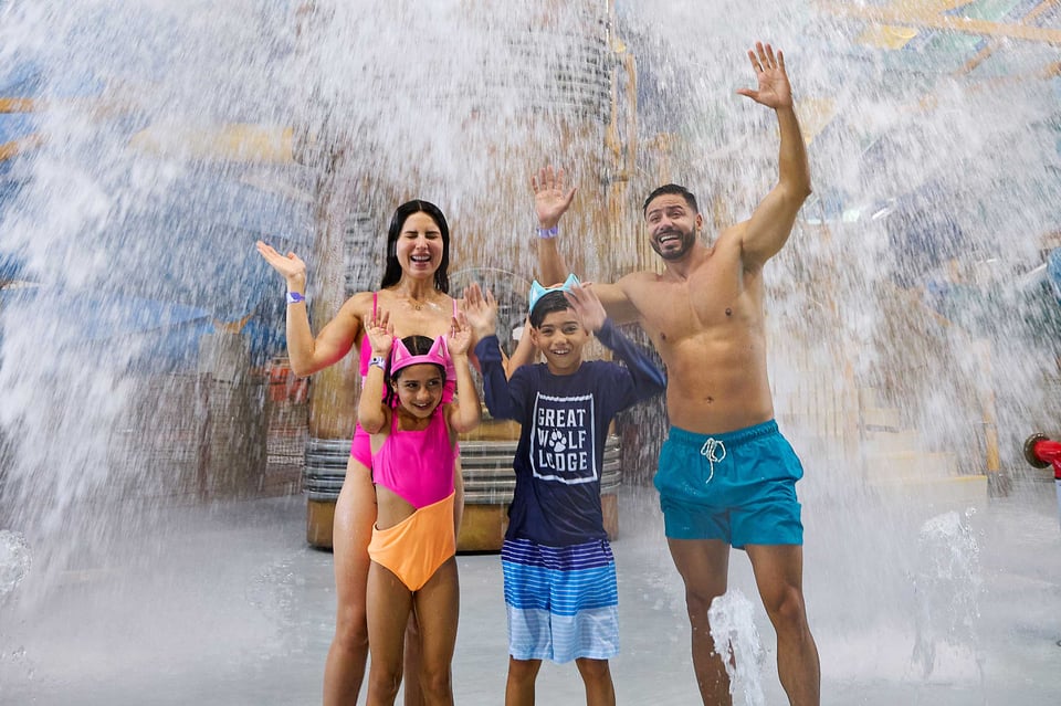 family standing under water and getting soaked