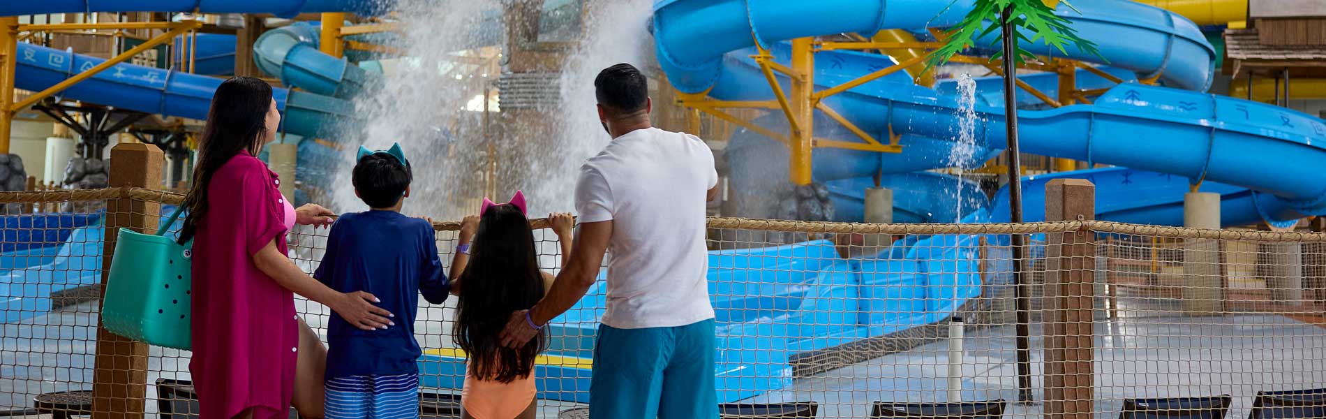 family enjoying water falling from a big bucket