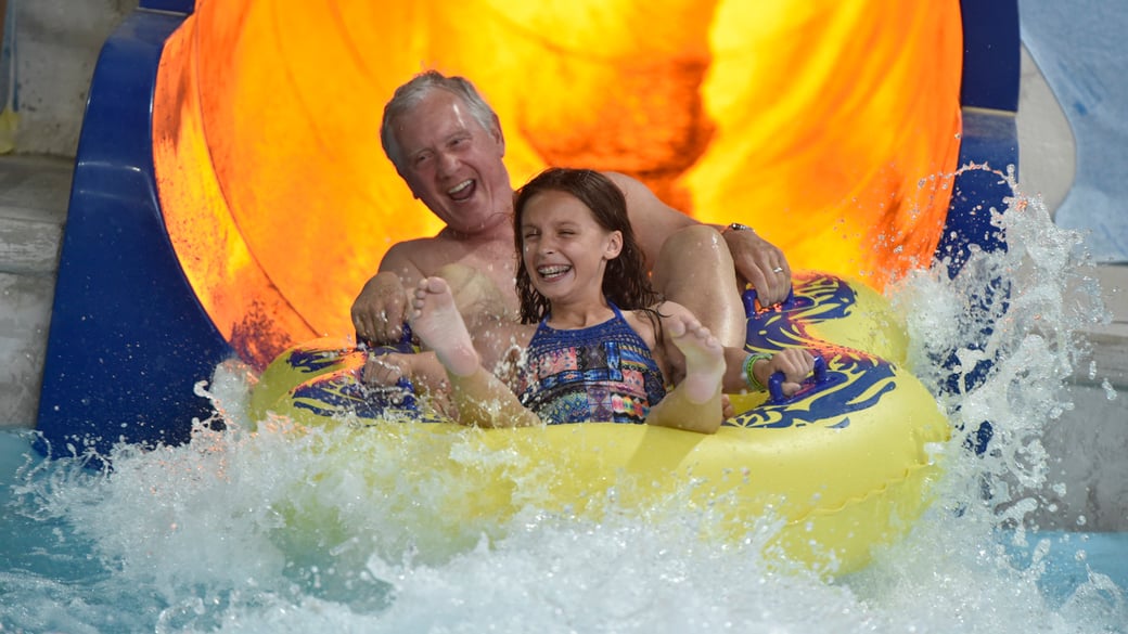 Grandpa and Grand-daughter slide down the water slide 