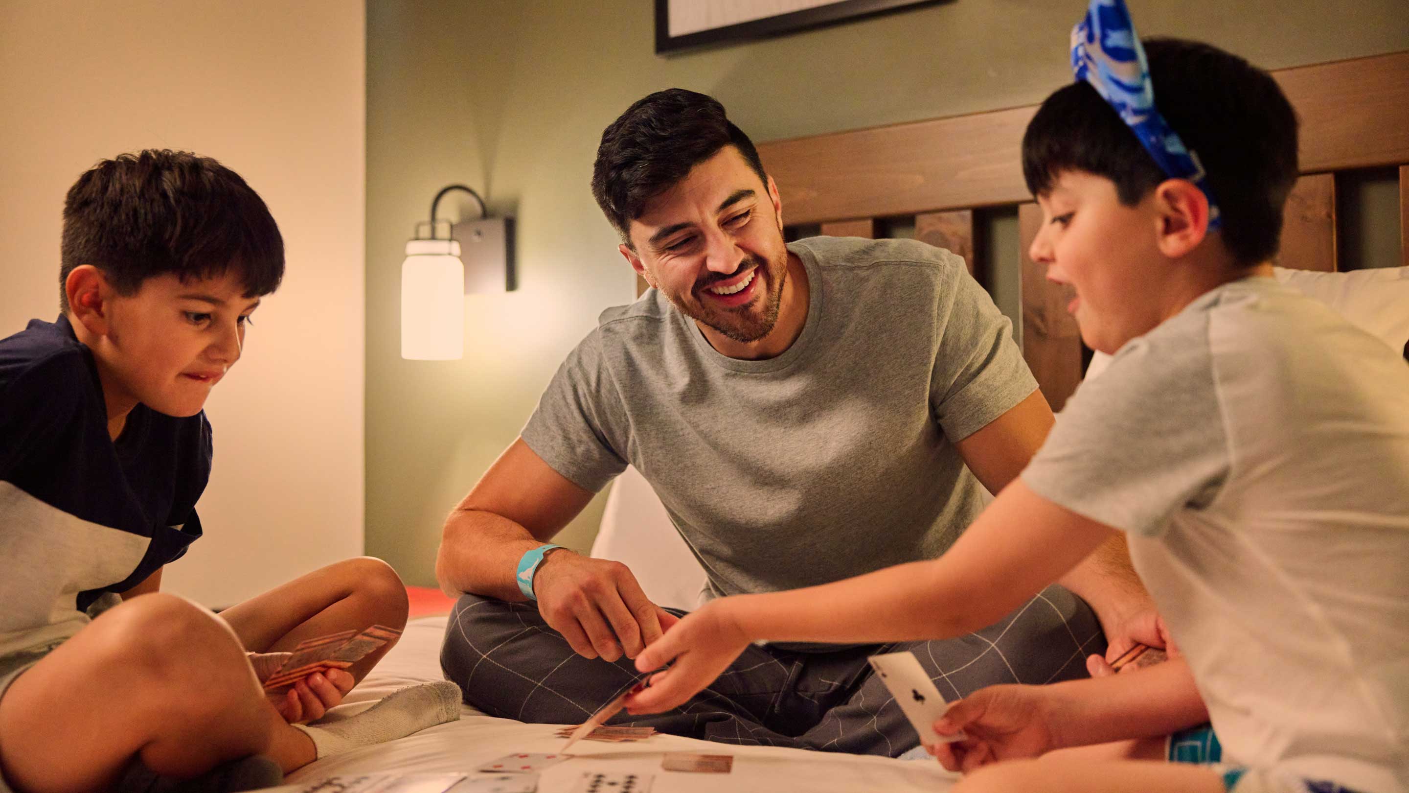 father and 2 sons playing a card game