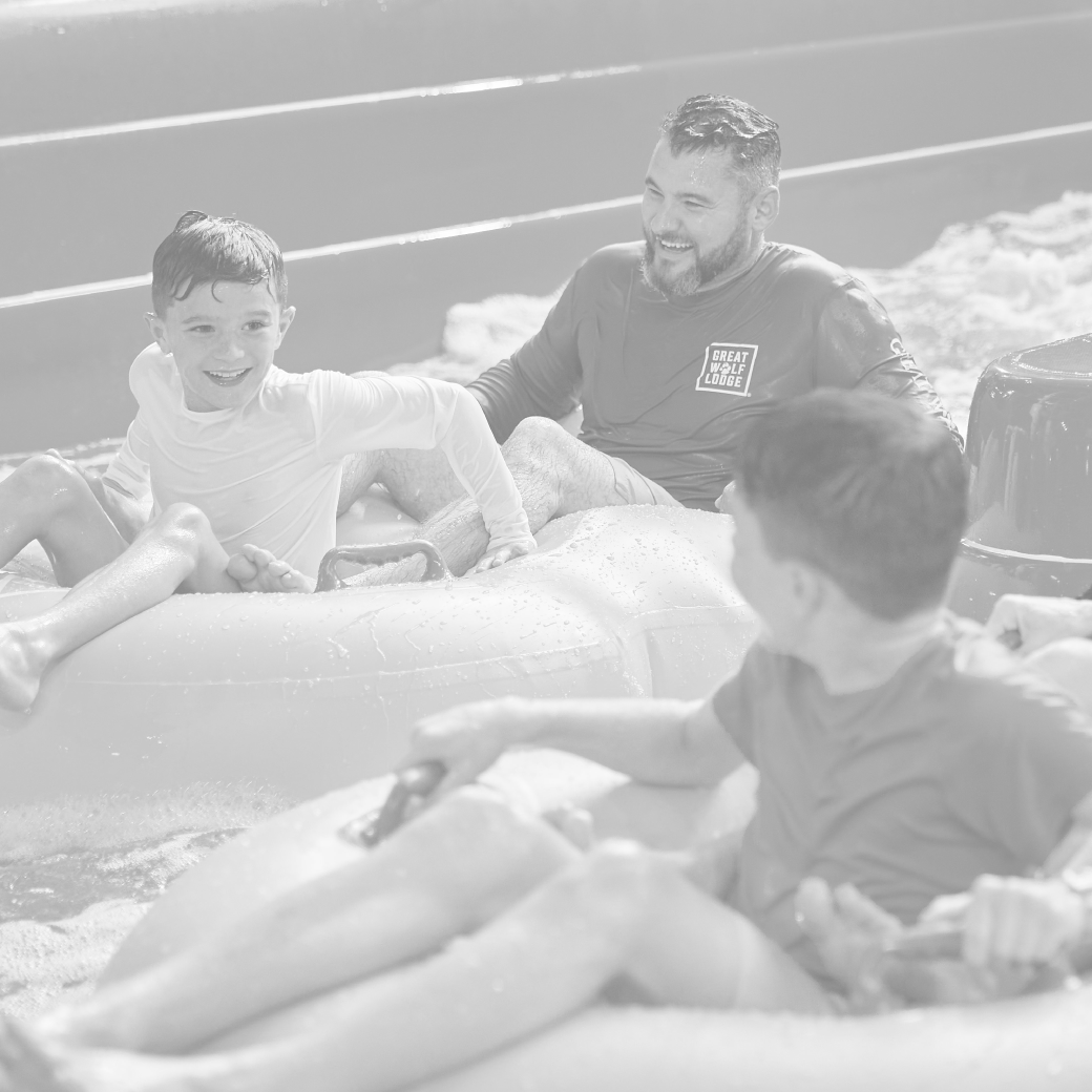 father and son riding tubes on a water slide