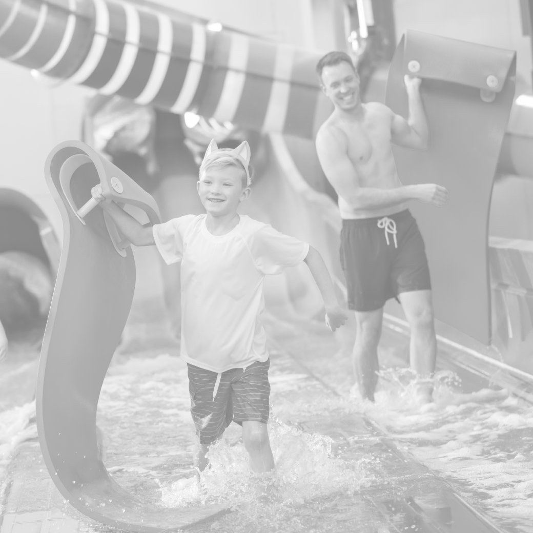 father and son sliding down a water slide using rubber mats