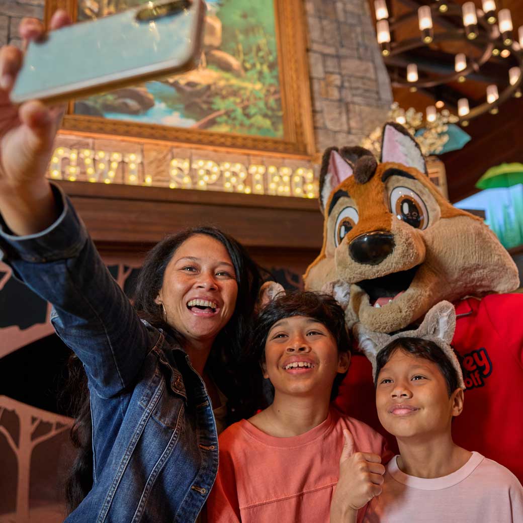 mother and kids taking a selfie with a wolf character