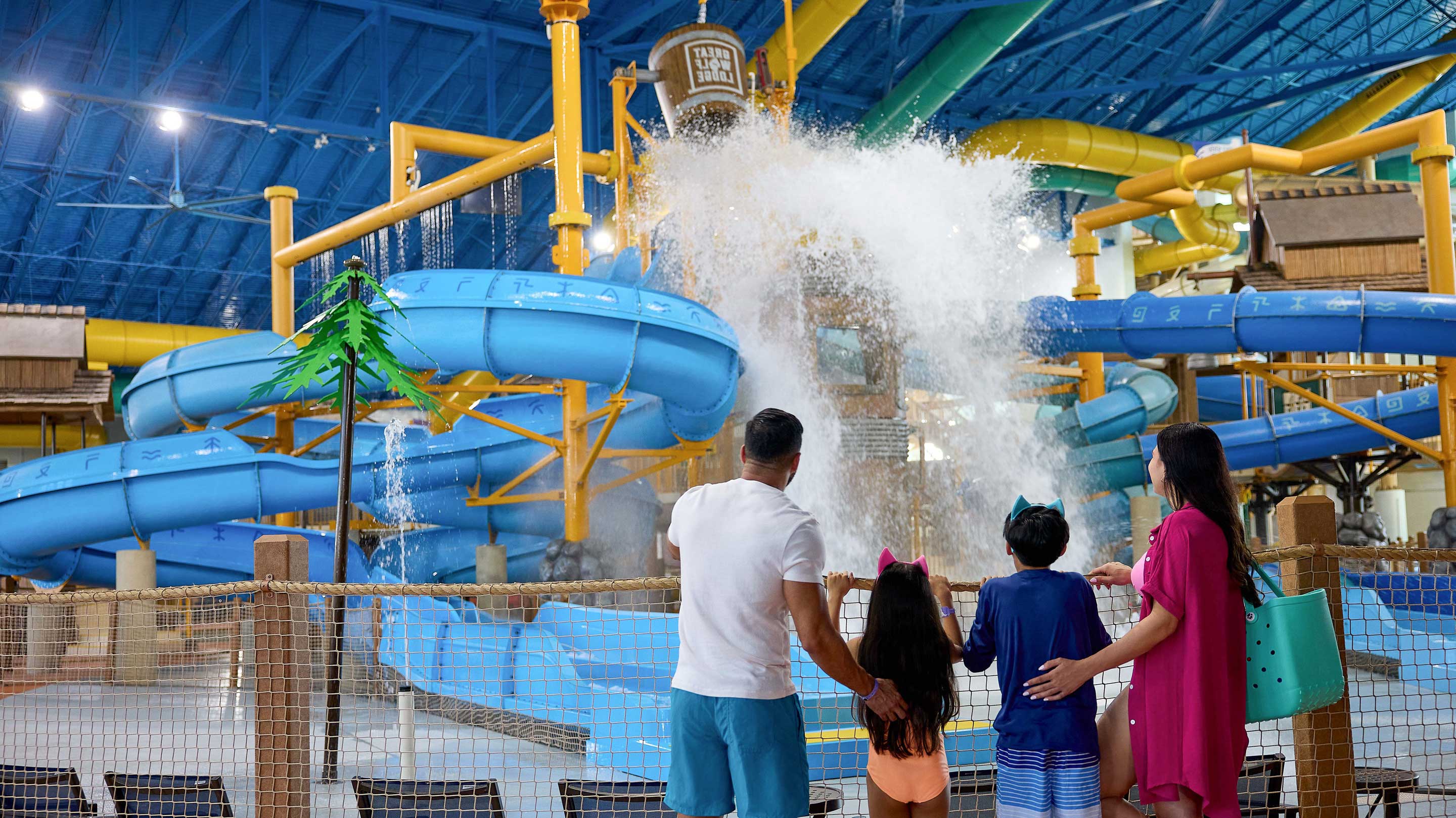 family standing in front of water bucket splashing water 