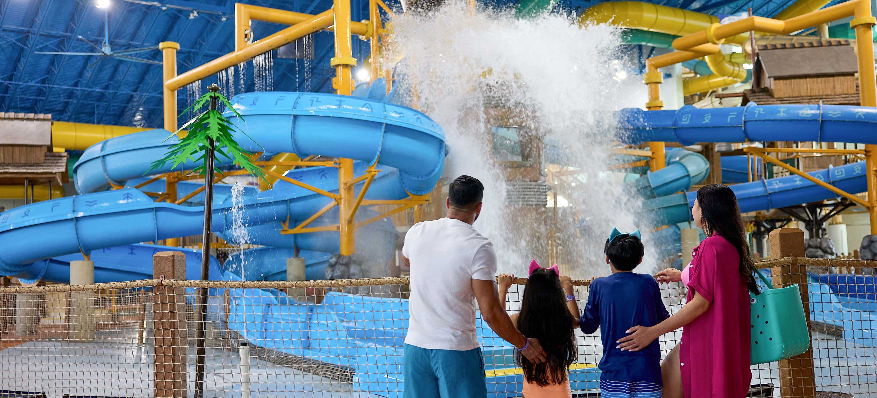 family standing in front of water bucket splashing water