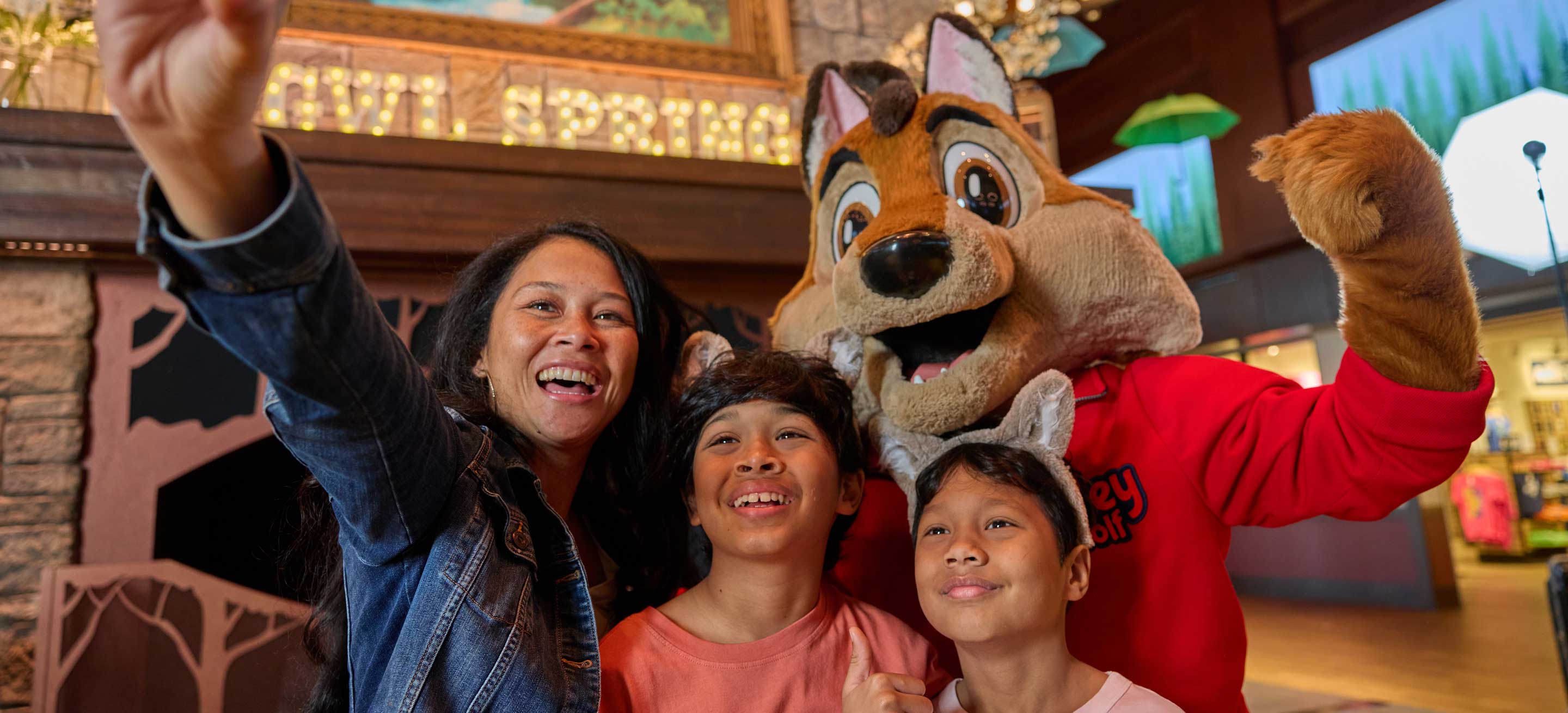 family taking a selfie with great wolf character