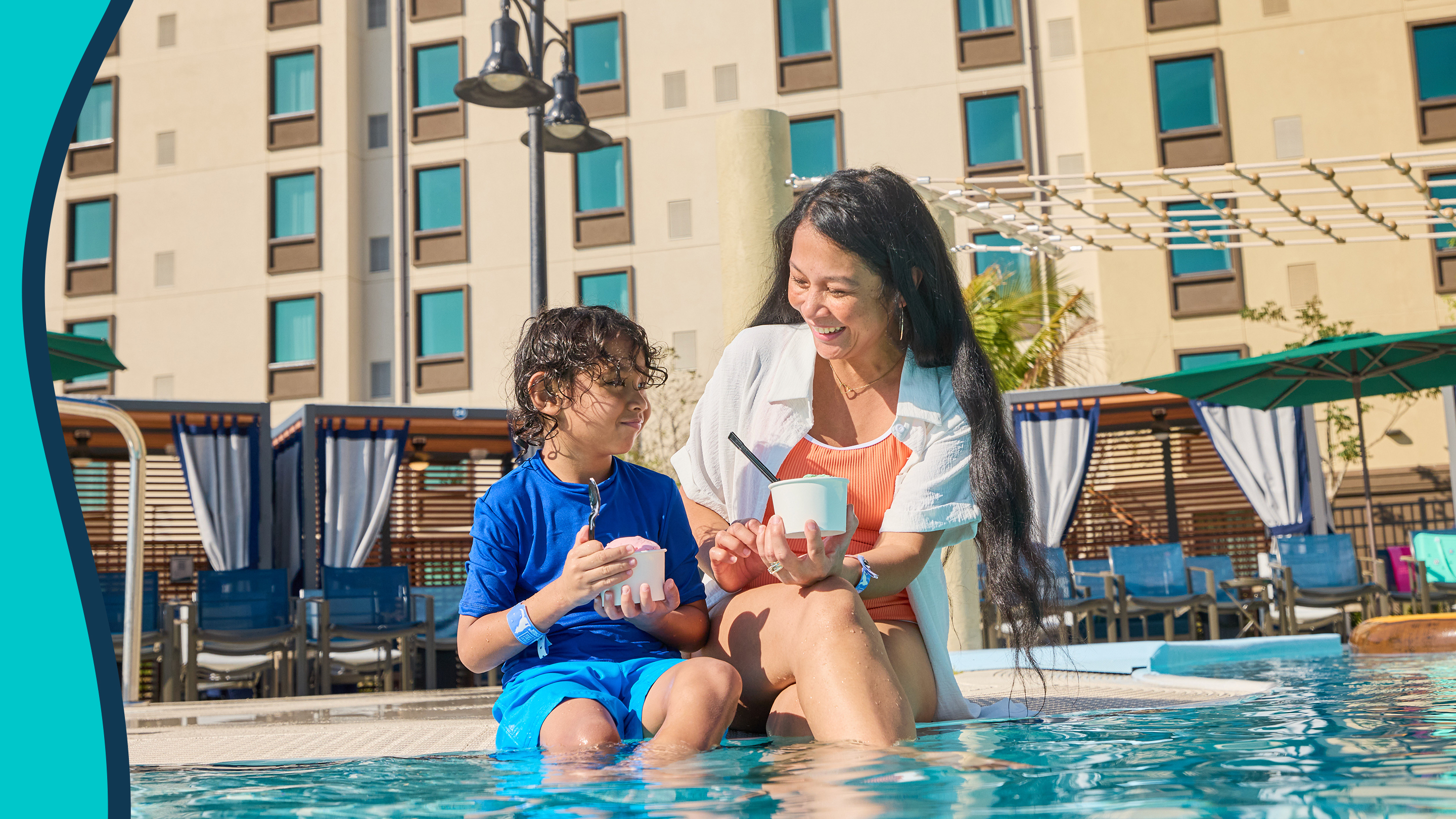 mother and kid sitting by the pool eating icecream