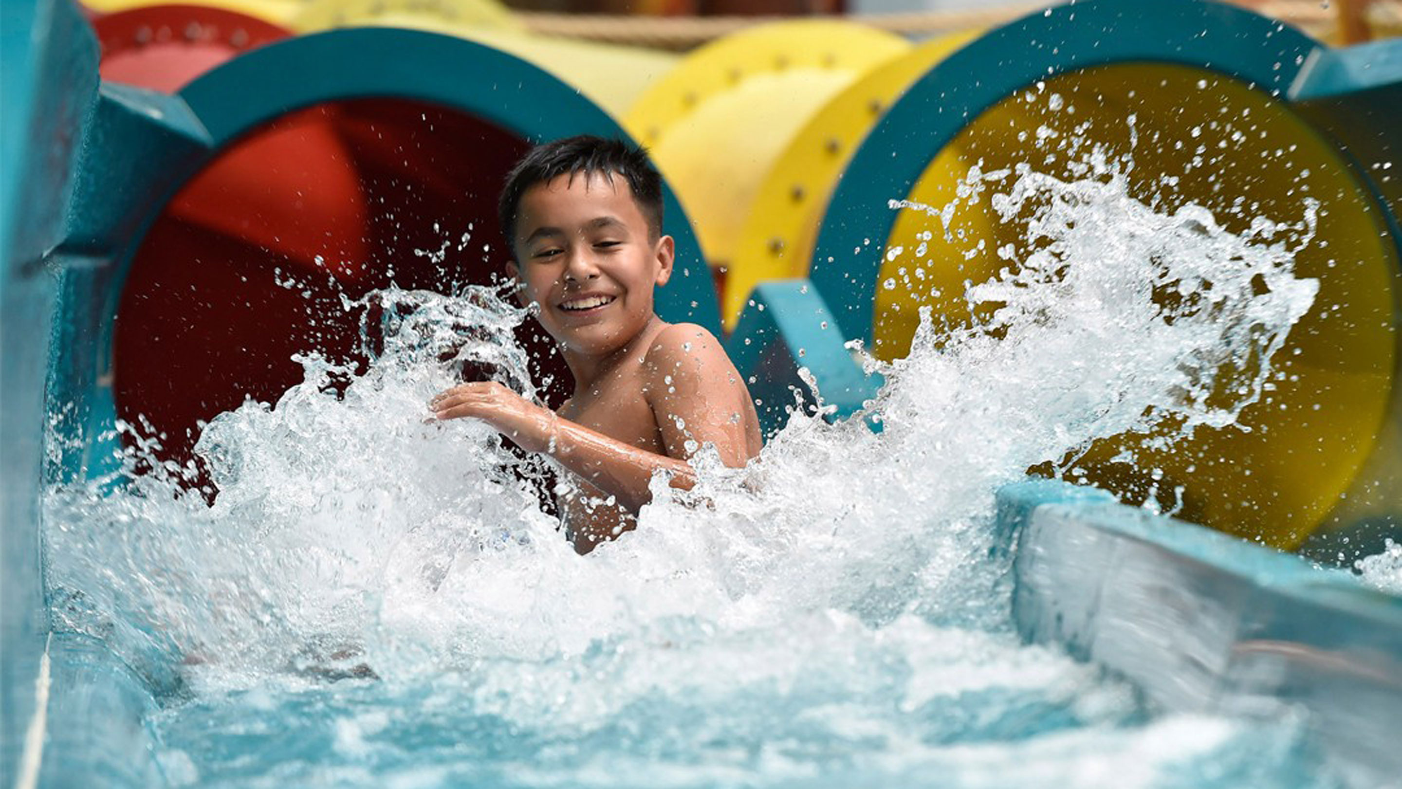 Boy splashing on a water slide