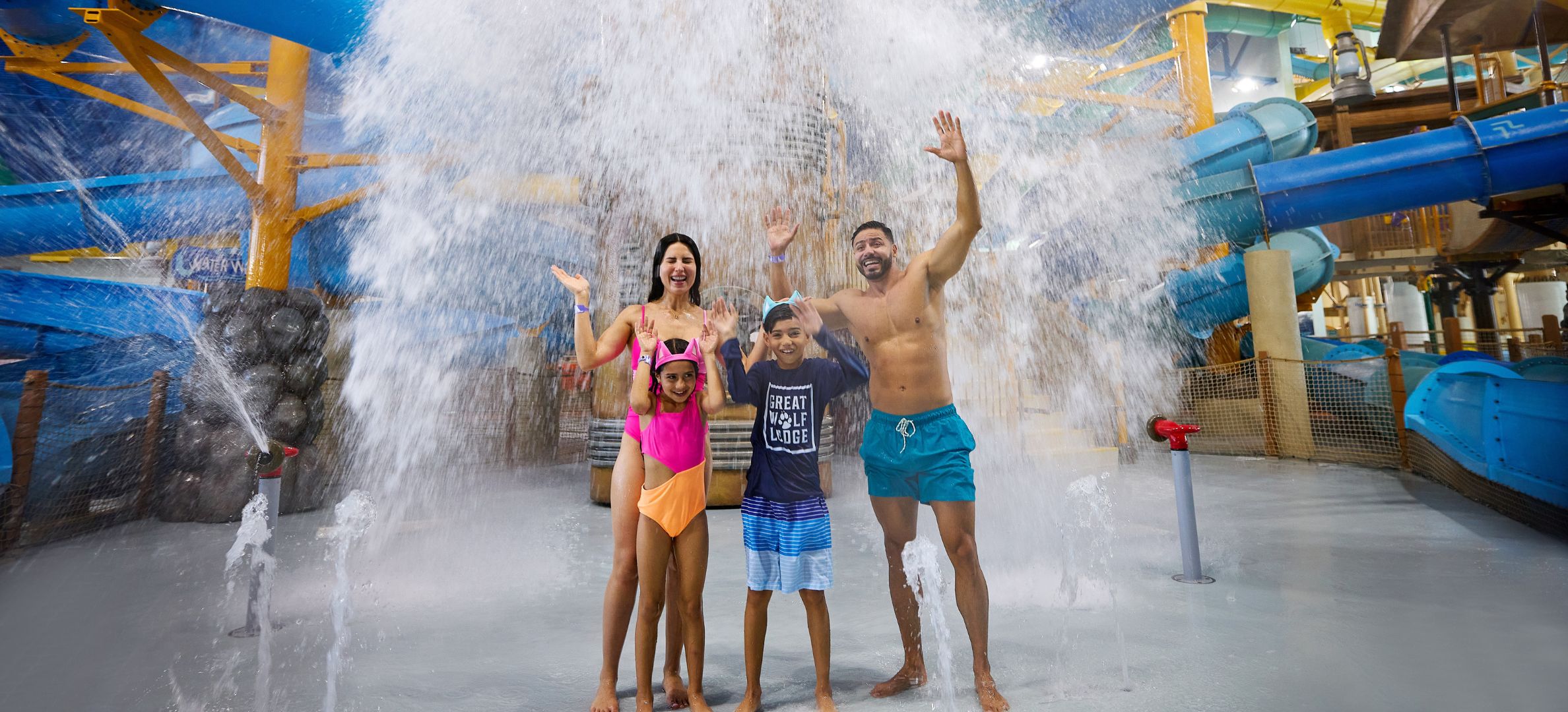 family standing in front of water bucket splashing water 