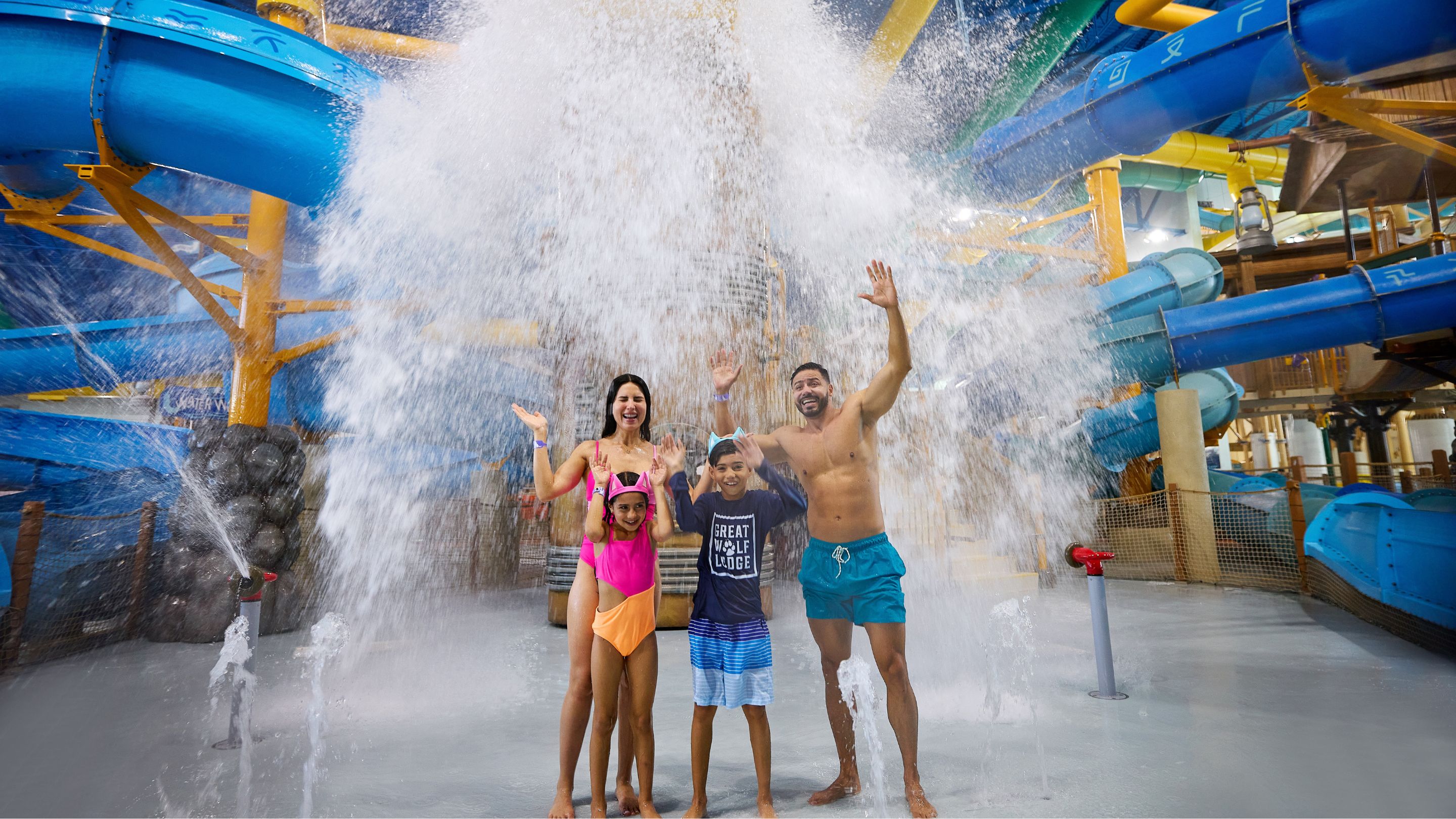 family standing in front of water bucket splashing water 