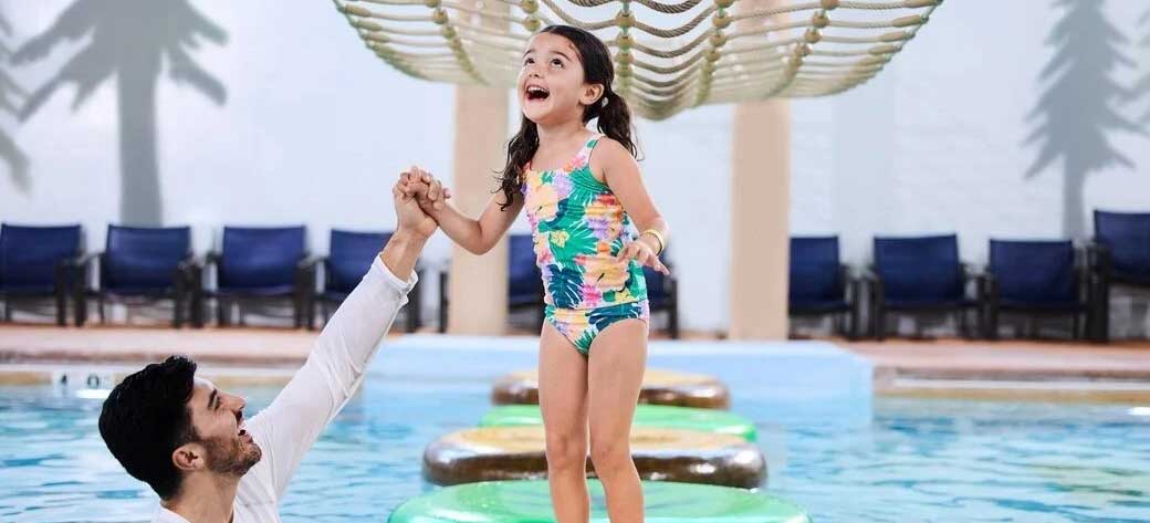 father and daughter enjoying in a pool at the waterpark