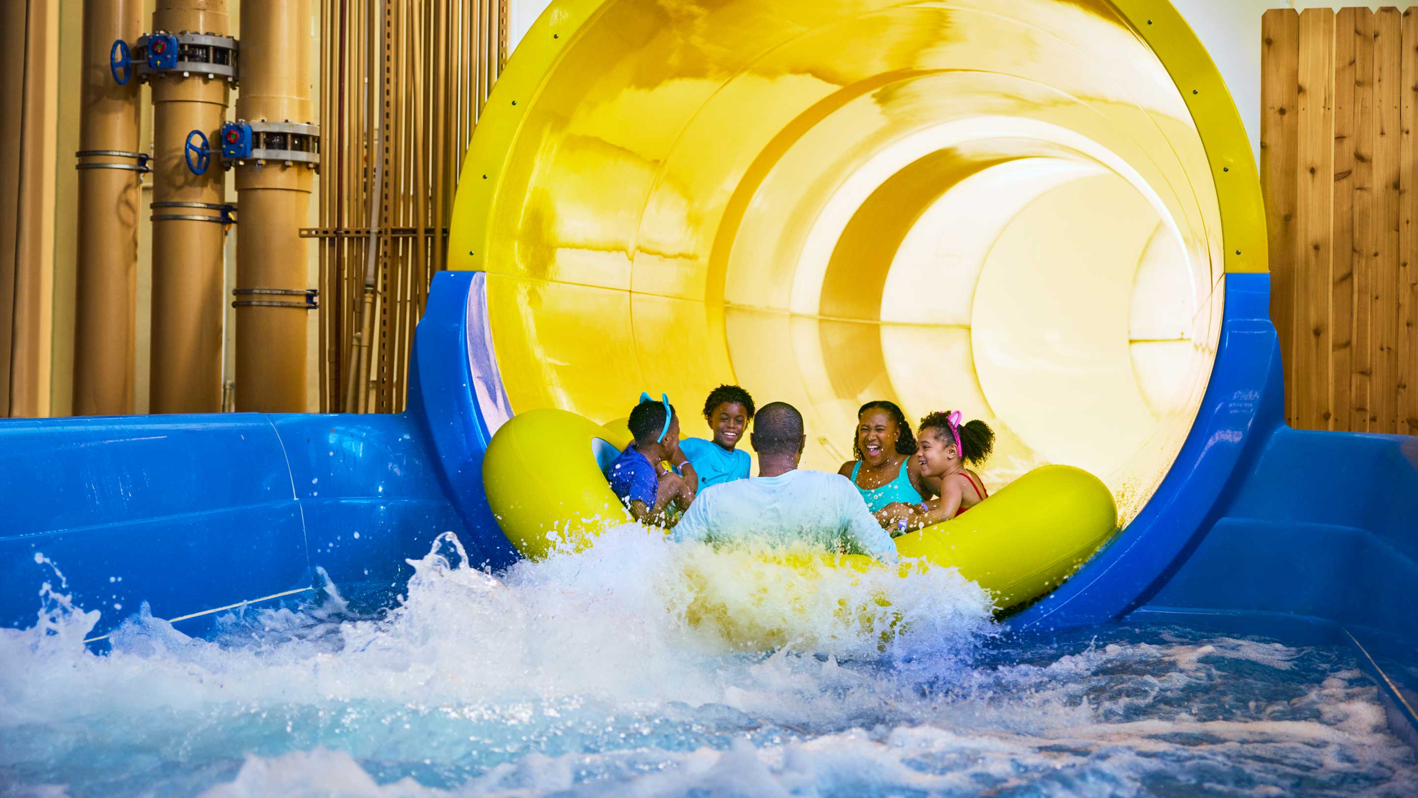 family sliding down a water slide on a rubber tube