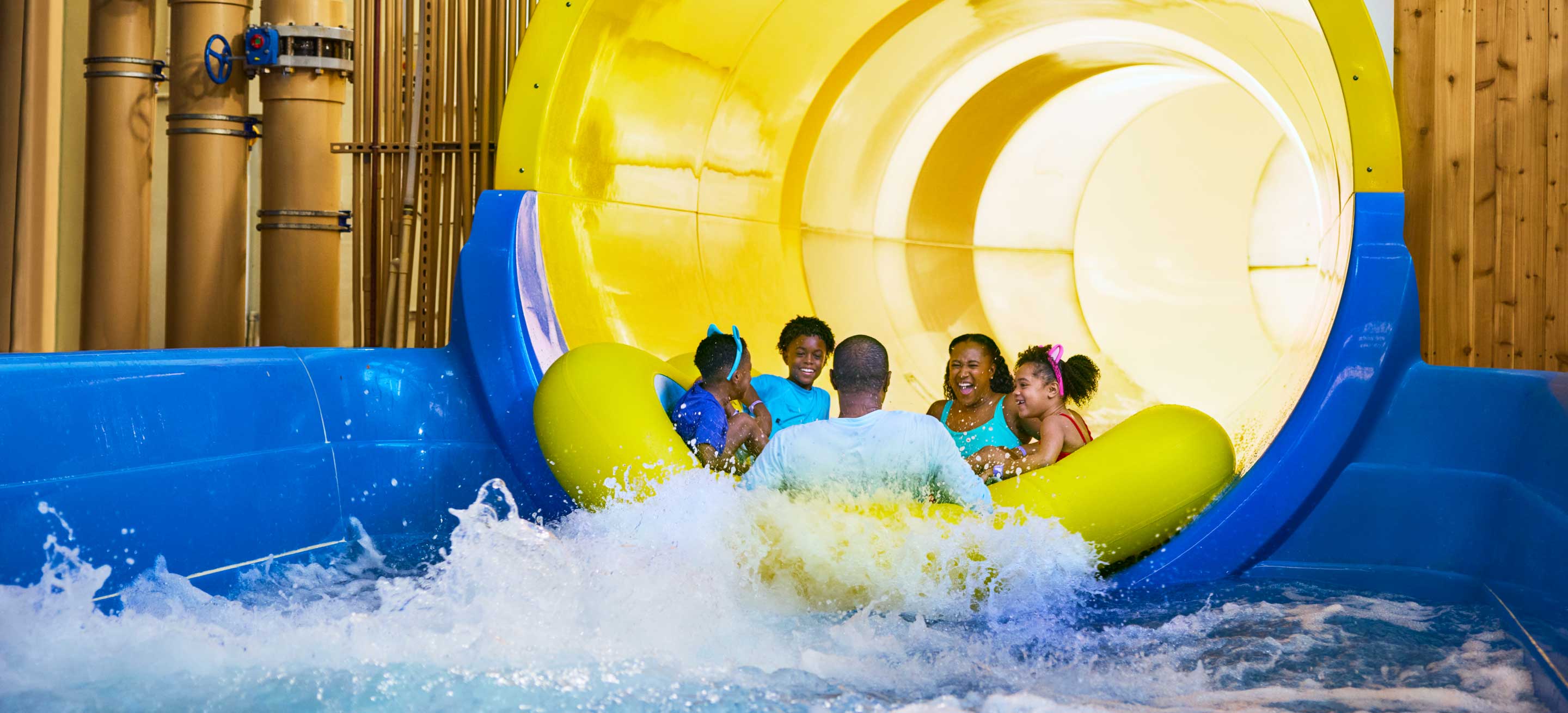 family sliding down a water slide on a rubber tube