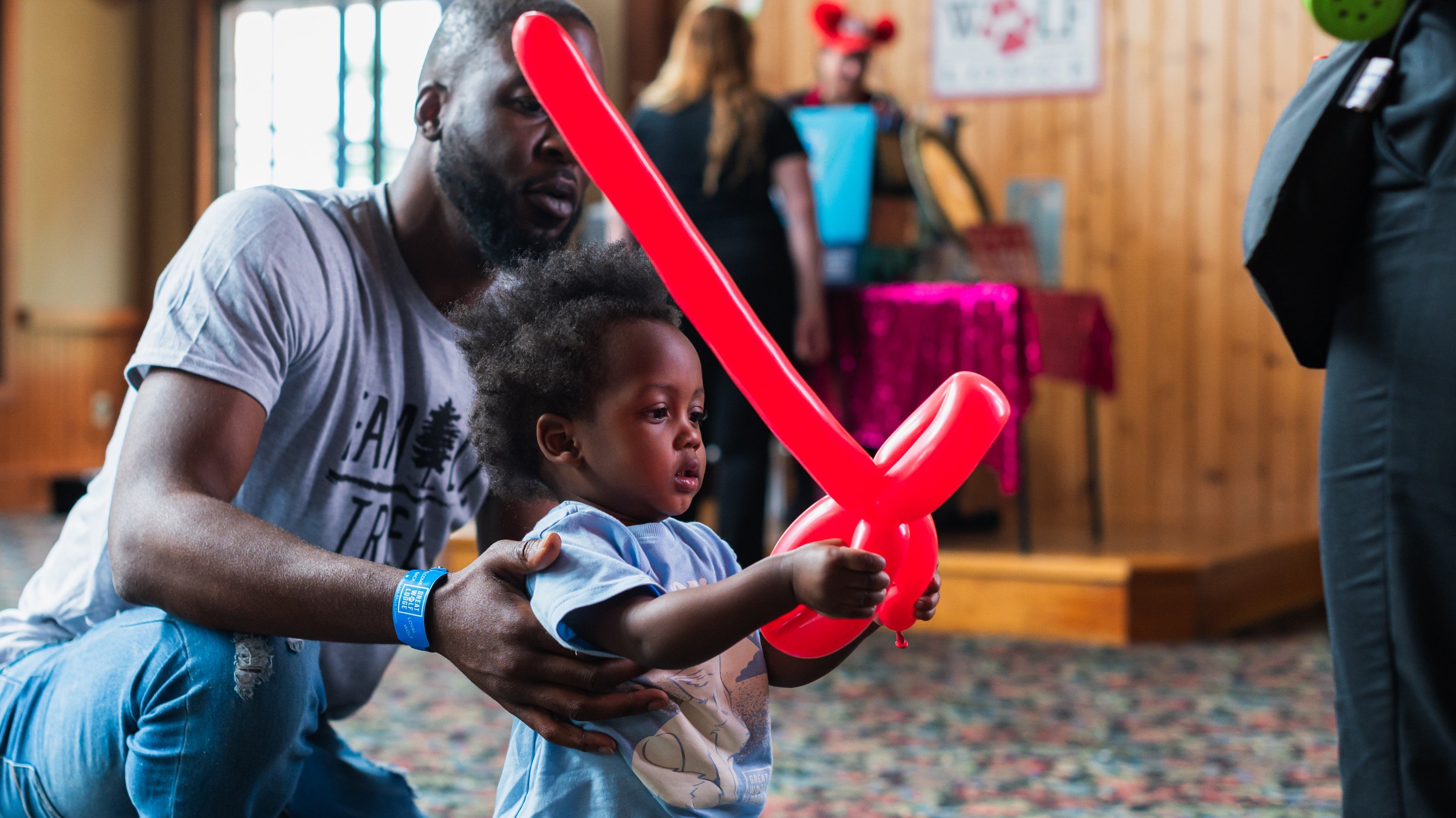 Father with his son holding a red color twisted balloon