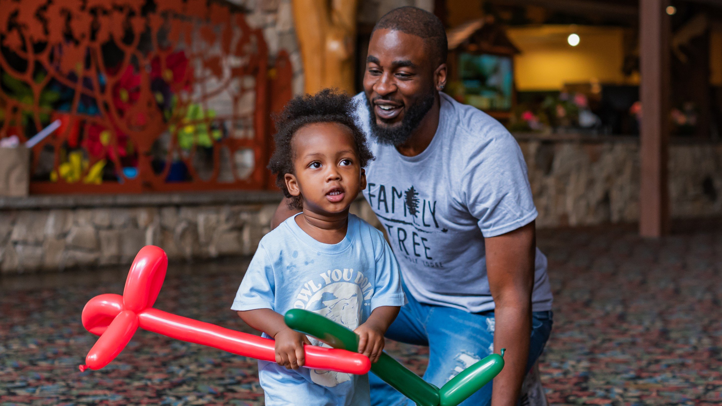 Little kid holding twisted balloons