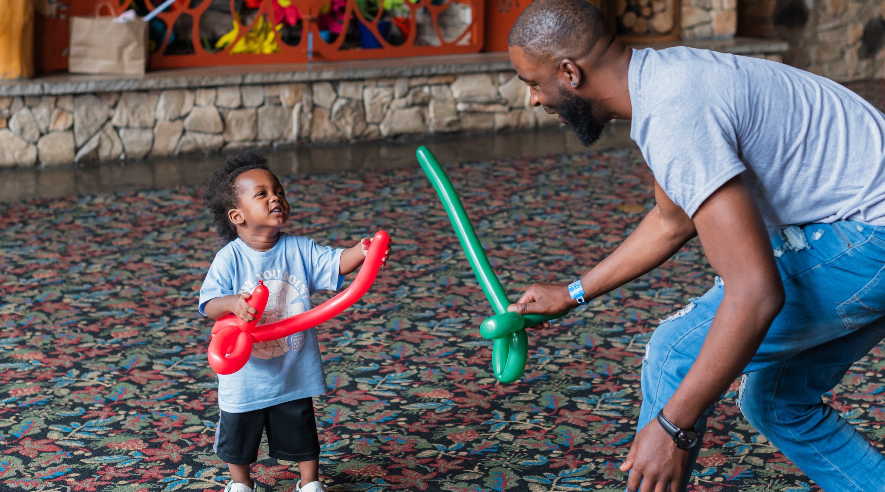 Son and his father holding twisted balloon