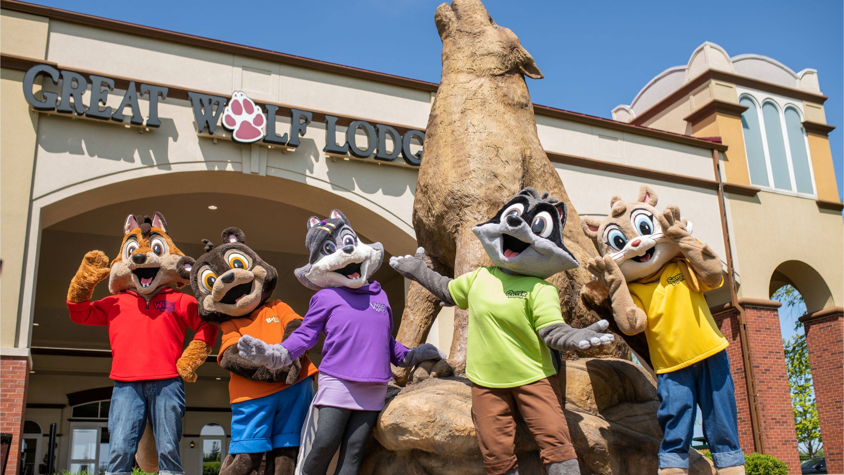Great Wolf Lodge mascots posing in front of entrance statue