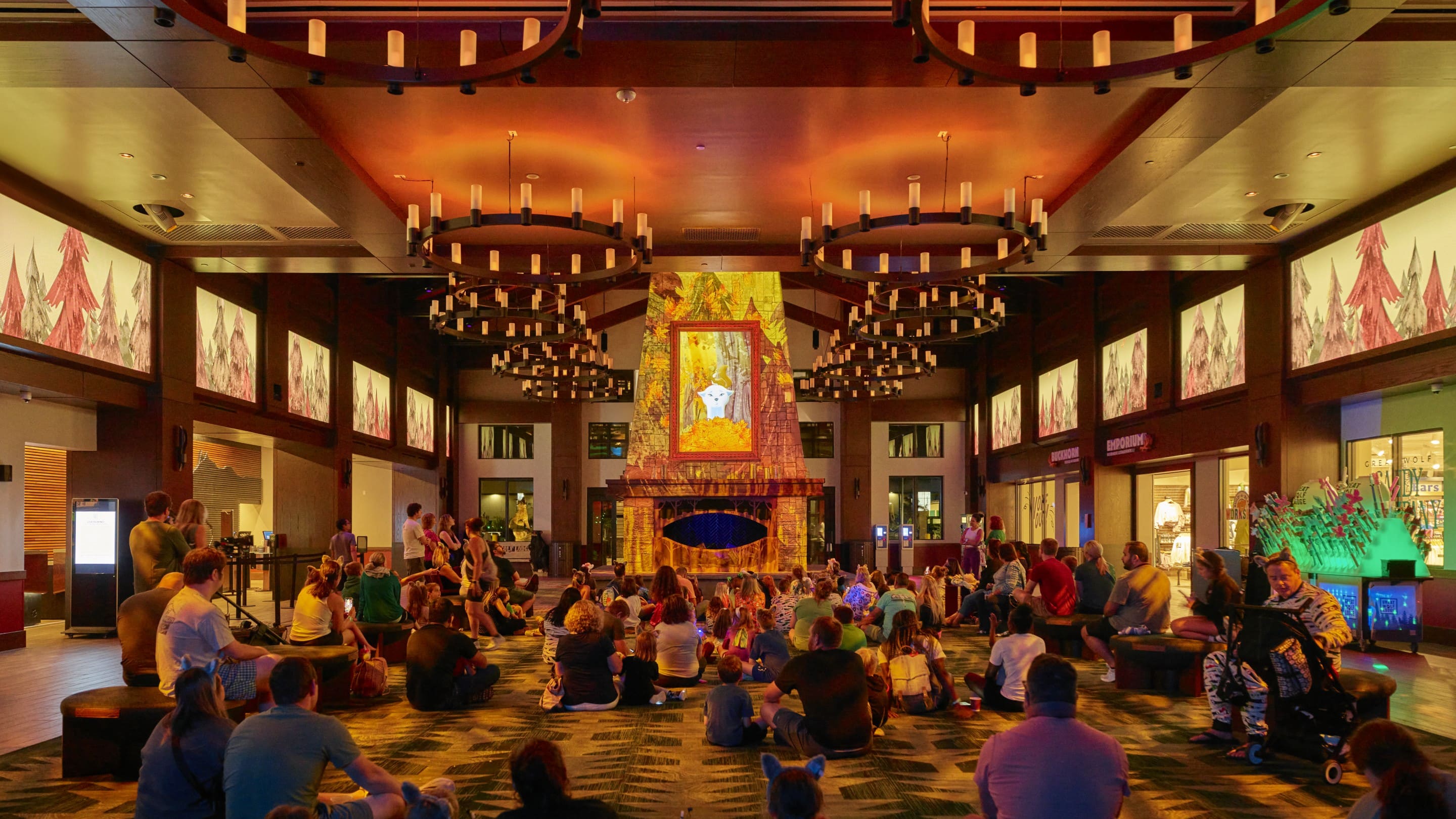 Families gathered in a lodge watching animated storytime by fireplace